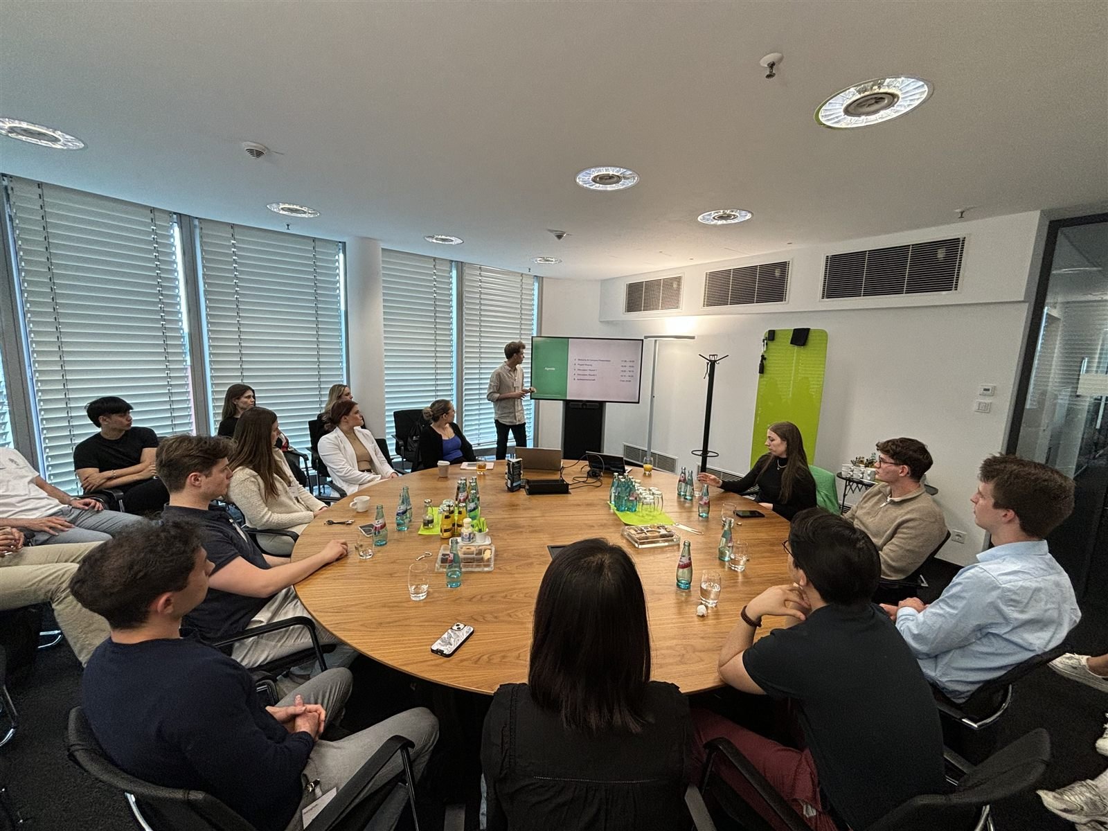 Students around a table listening to a presentation at a partner firm